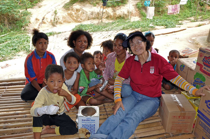 Auntie Rose giving biscuit to orang asli children