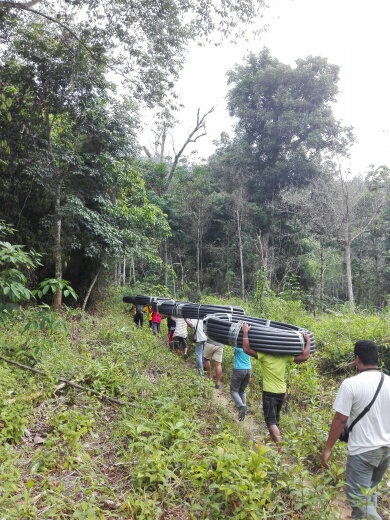 Kg Sinju villagers and SOA bringing pipes into hills for water source