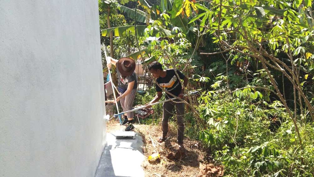 SOA member and Itam painting the undercoat of exterior walls
