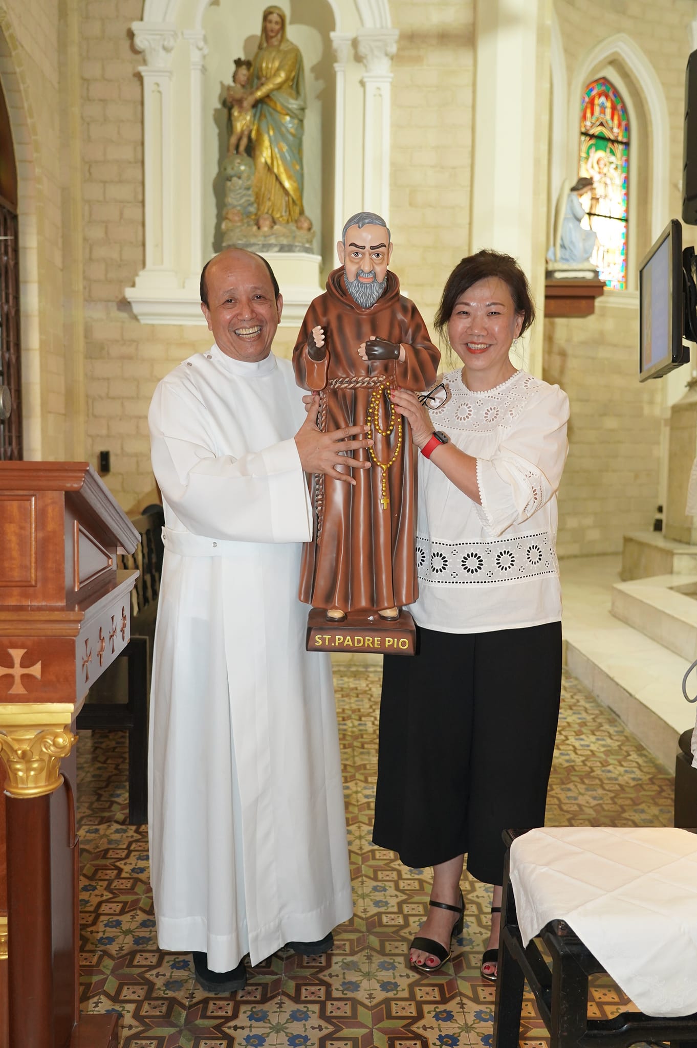 Fr Oscar presenting Padre Pio statue to Ms Gwen Ng, Chairman of Padre Pio Group